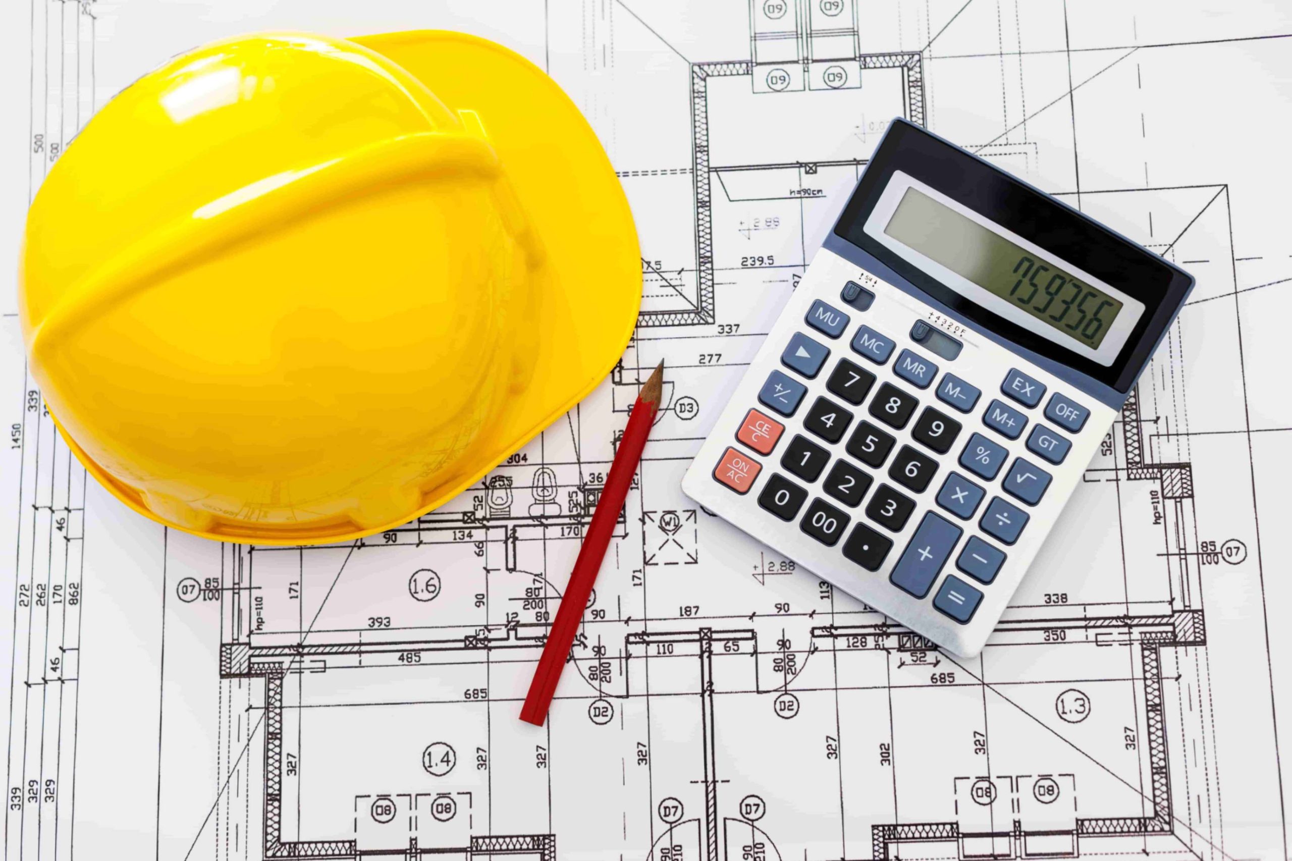 Construction cap, calculator and pencil on top of a house blueprint
