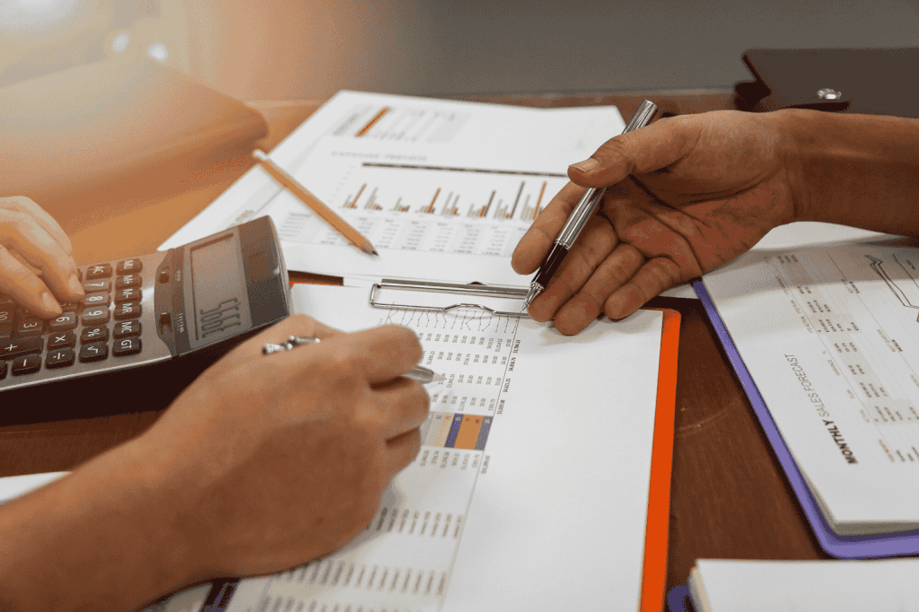 Two people working together on a financial report, using a calculator and a pen
