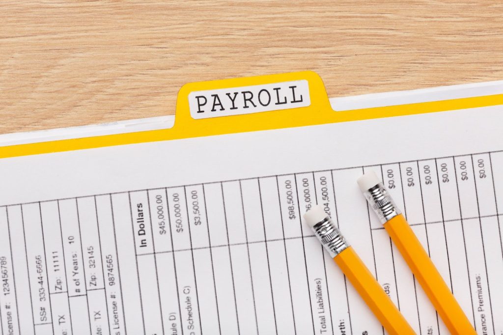 A payroll document with a yellow file folder labeled "PAYROLL"