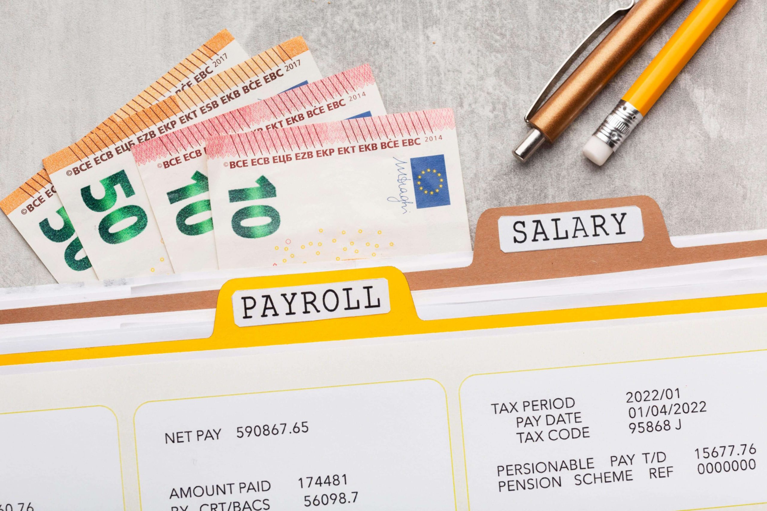 Euro bills with payroll and salary documents.