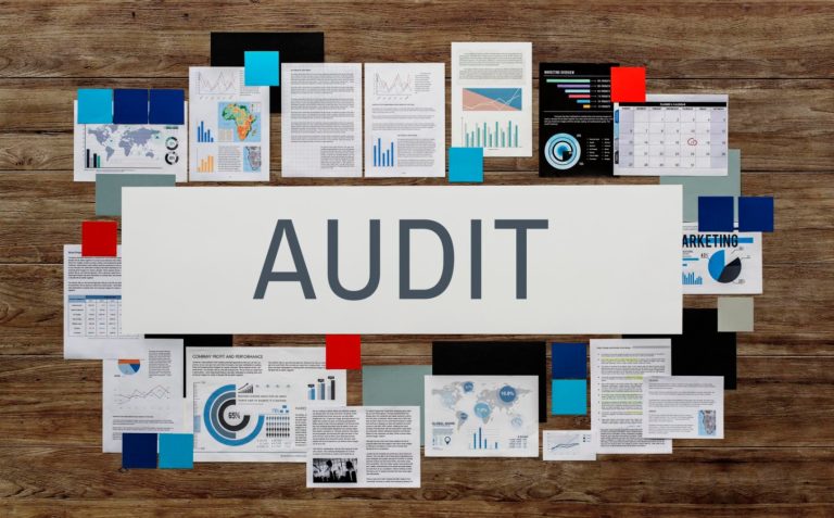 Audit documents and financial reports kept on a wooden table