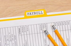 payroll file and pencils on a table